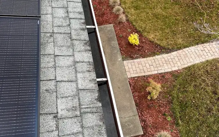 Looking down the full length of a clean gutter run from the roof